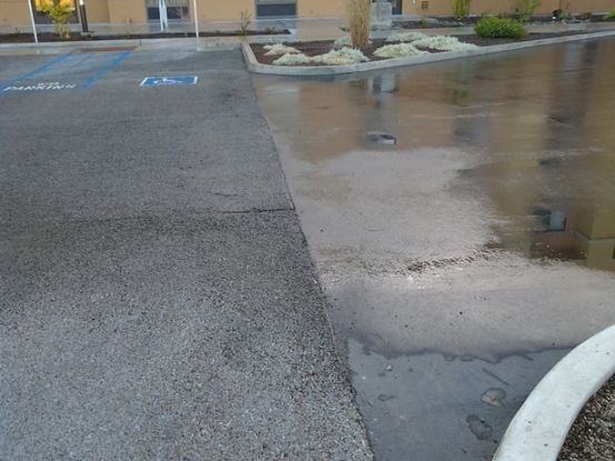 Pervious pavement (left side) and traditional impervious pavement (right side).  Areas of pooled water are seen on the impervious surface